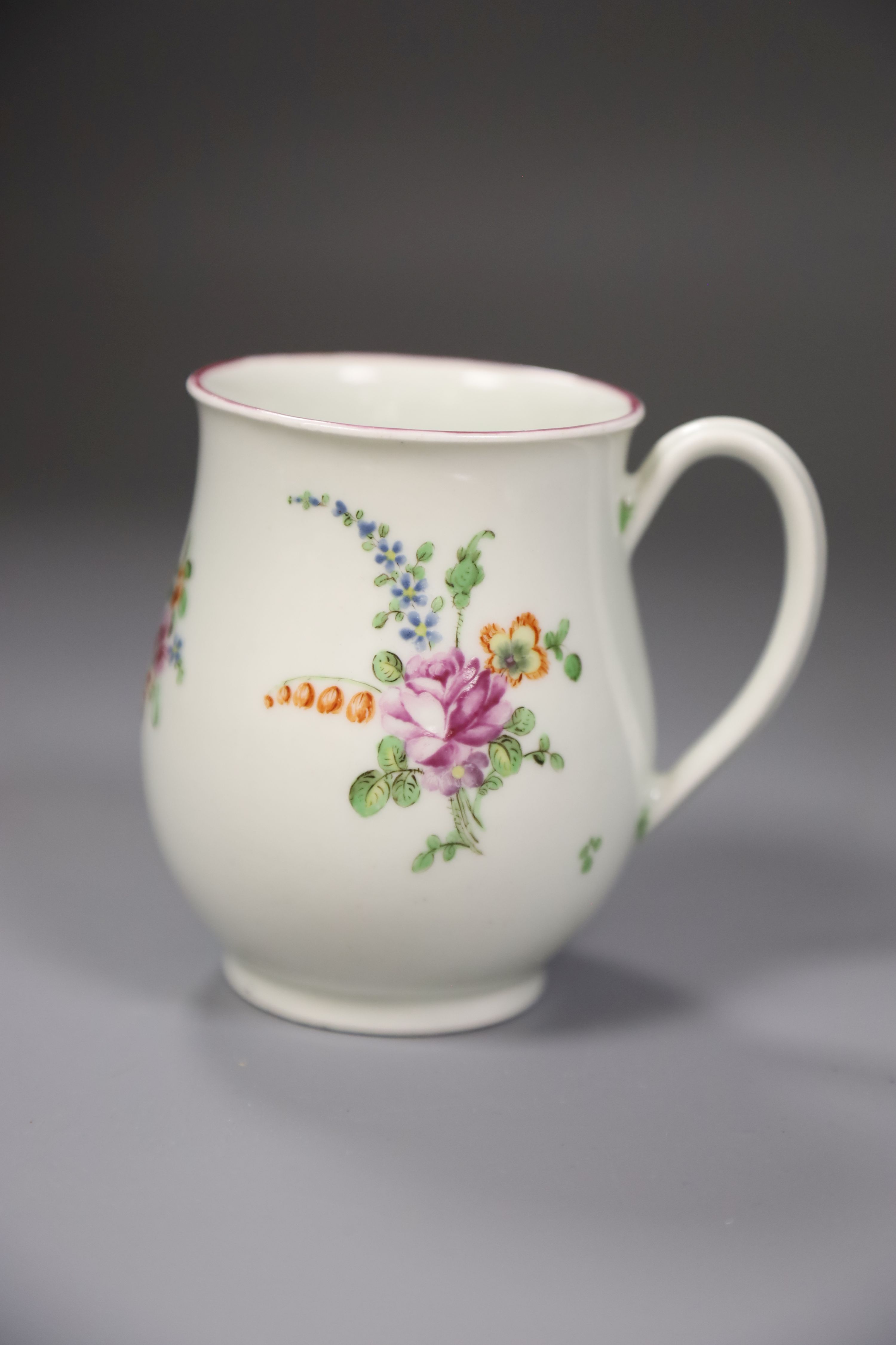 A Worcester bell shape mug painted with scattered coloured flowers, height 9cm